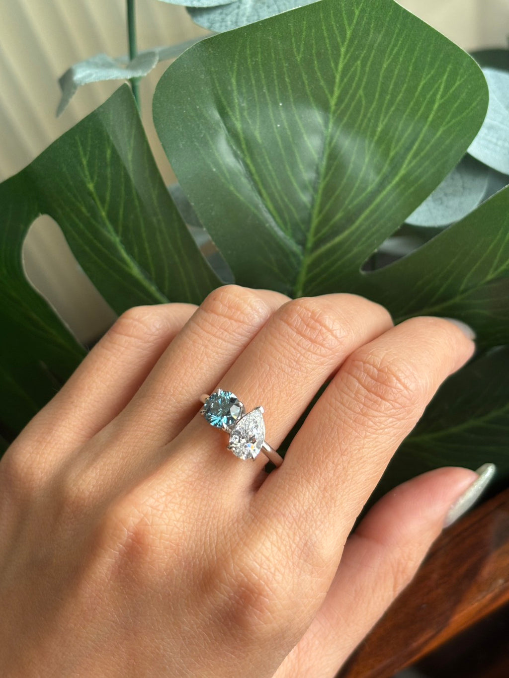 47AU Toi et Moi ring with vivid blue and white lab-grown diamonds worn on a hand