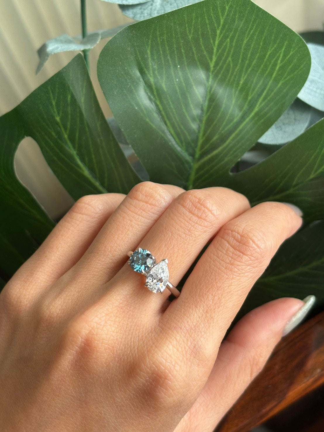 47AU Toi et Moi ring with vivid blue and white lab-grown diamonds worn on a hand